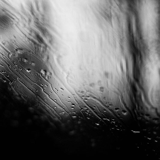 Coastal Noir 7933 - Close Detail View, abstract black and white coastal image with fine rain droplets on glass creating subtle horizontal lines and textures.