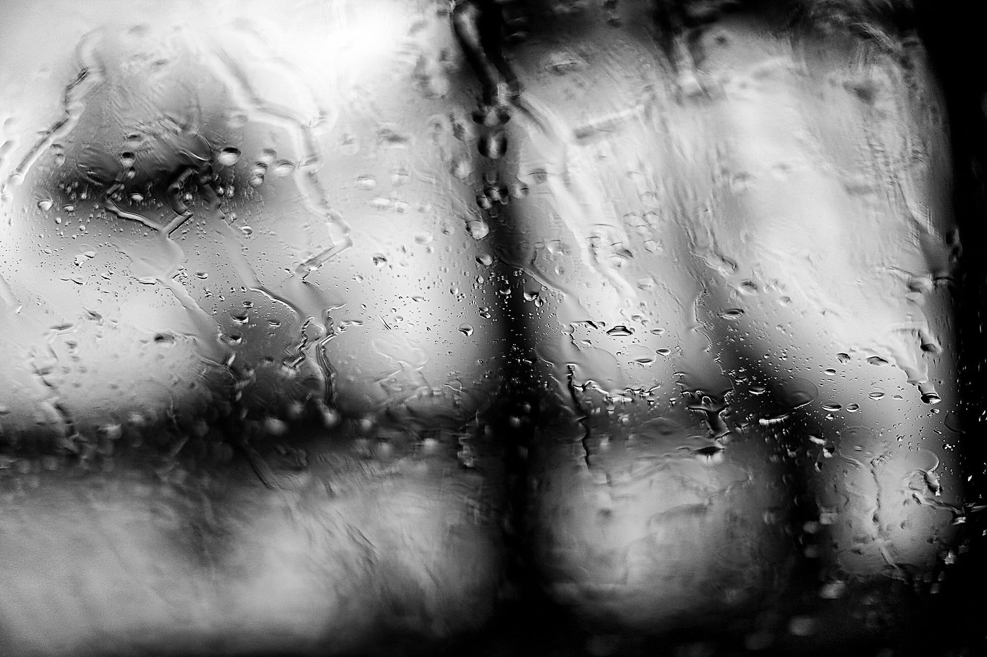 Coastal Noir 8007 - 90x60cm, black and white coastal scene with rain on glass and abstracted tree forms in soft focus.