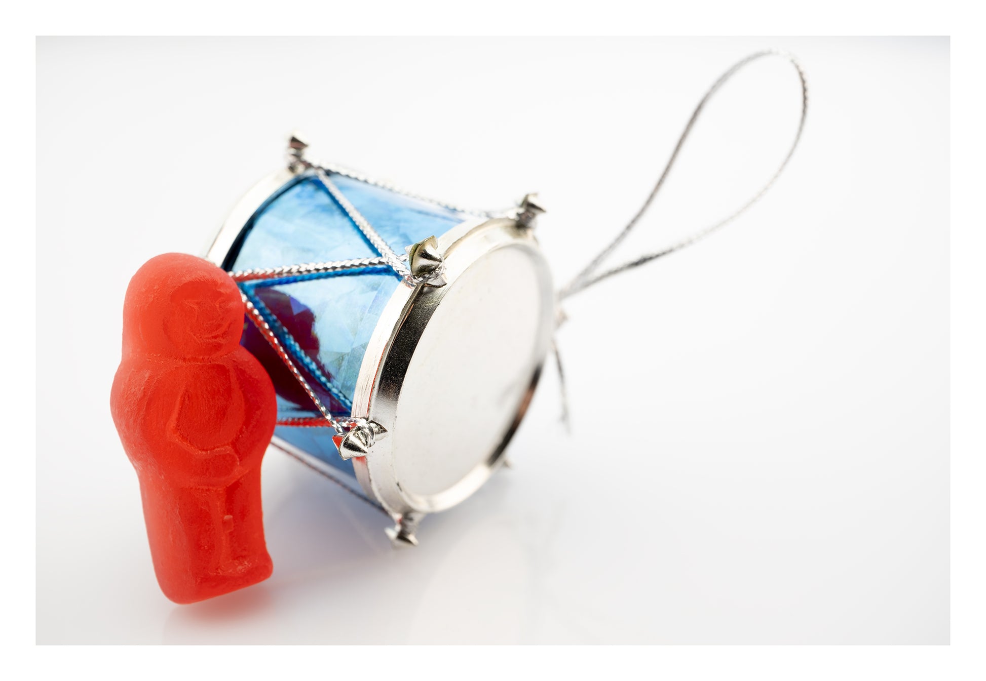 Beat of a Different Drum 2948 - 104x74cm, red jelly figure leaning on a miniature blue drum ornament, fine art photographic print by Raymond Mather, ART1.