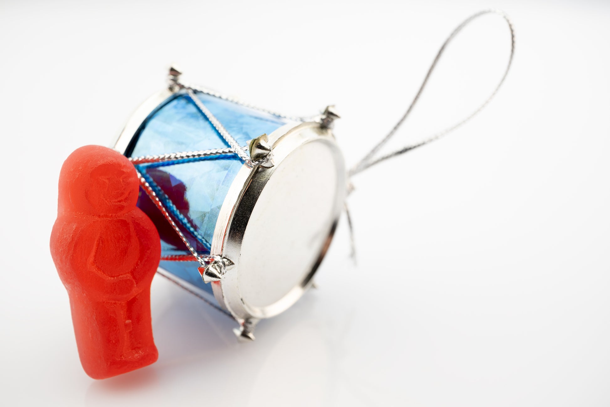 Beat of a Different Drum 2948 - 90x60cm, red jelly figure leaning on a miniature blue drum ornament, fine art photographic print by Raymond Mather, ART1.