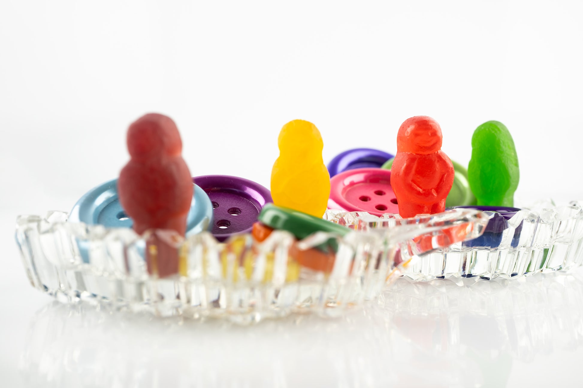 Cute As a Button 2546 - 90x60cm, colourful jelly baby figures posed among large plastic buttons in a vintage-style cut glass dish, fine art photographic print by Raymond Mather, ART1.