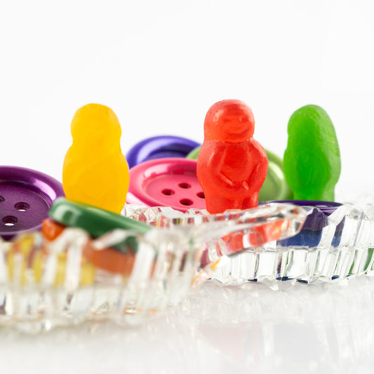 Cute As a Button 2546 - Close Detail View, colourful jelly baby figures posed among large plastic buttons in a vintage-style cut glass dish, fine art photographic print by Raymond Mather, ART1.
