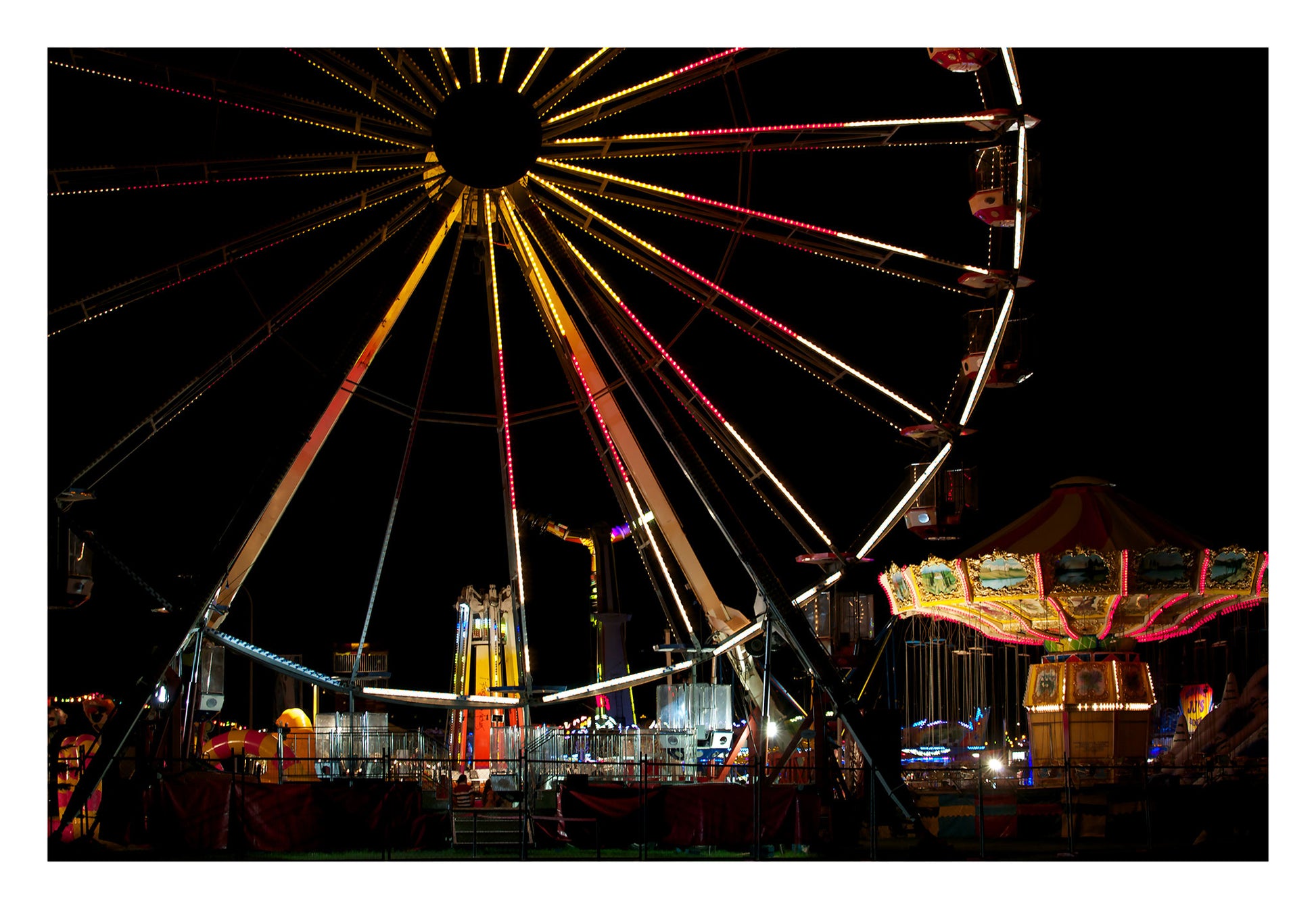Fairground Carnival Lights 6900003v3 - 104x74cm, Ferris wheel glowing against twilight sky with carnival rides below, fine art limited edition print by Raymond Mather, ART1.