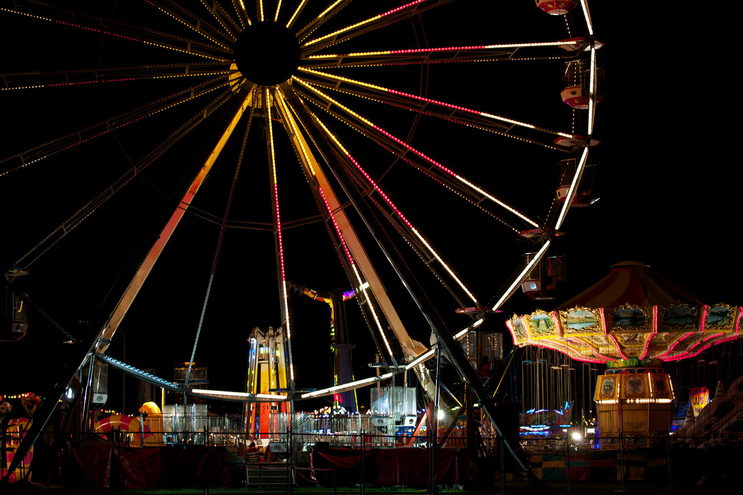 Fairground Carnival Lights 6900003v3 - 90x60cm, Ferris wheel glowing against twilight sky with carnival rides below, fine art limited edition print by Raymond Mather, ART1.