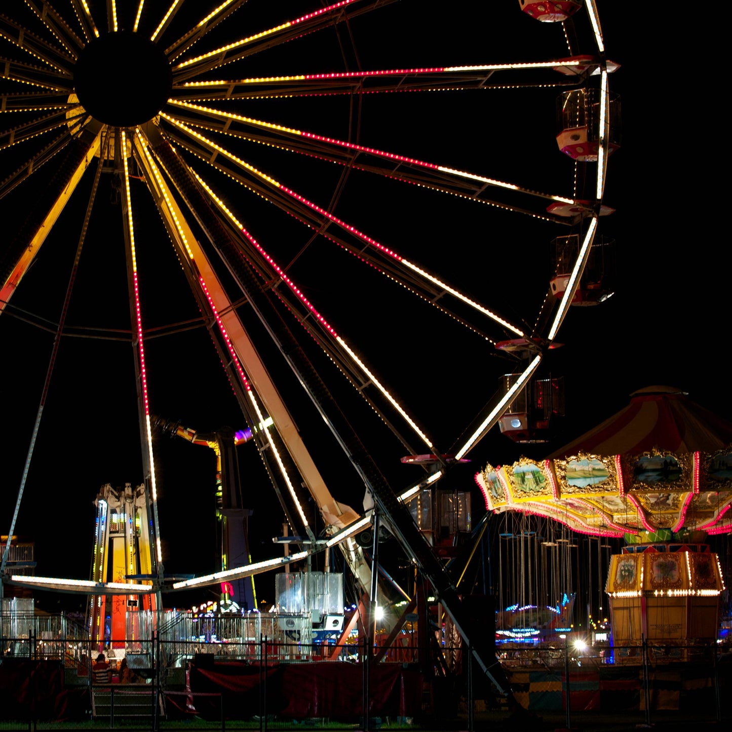 Fairground Carnival Lights 6900003v3 - Close Detail View, Ferris wheel glowing against twilight sky with carnival rides below, fine art limited edition print by Raymond Mather, ART1.