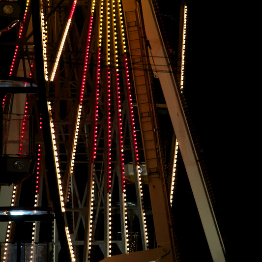 Fairground Carnival Lights 6900085 - Close Detail View, abstract detail of Ferris wheel spokes lit in red, yellow, and white against dark sky, fine art limited edition print by Raymond Mather, ART1.