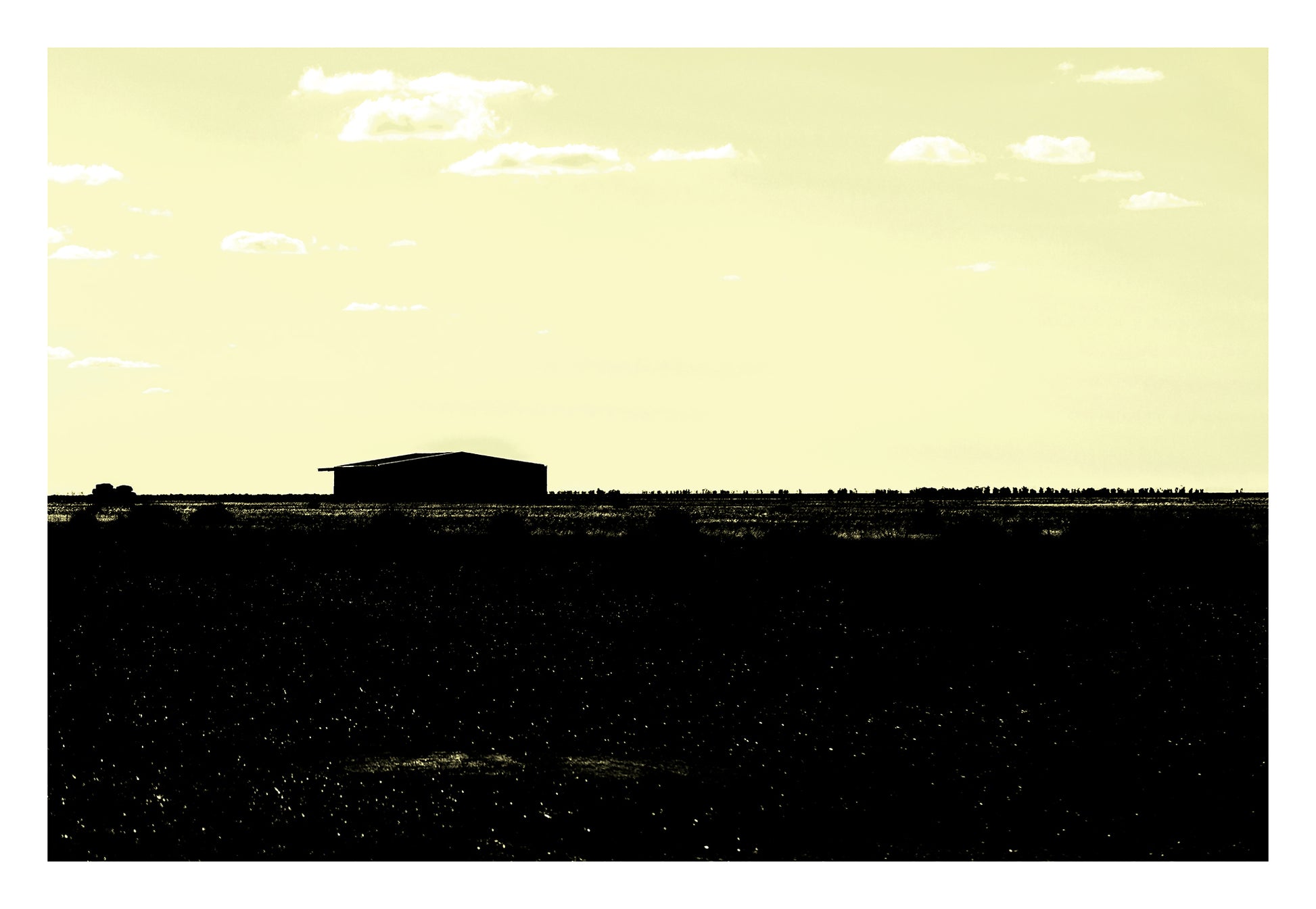 Vivid Country - Hay Plains Shed - 4945v17 - 104x74cm, a silhouetted shed on the vast Australian Hay Plains under a pale yellow sky, evoking stillness, space, and minimalist rural beauty.
