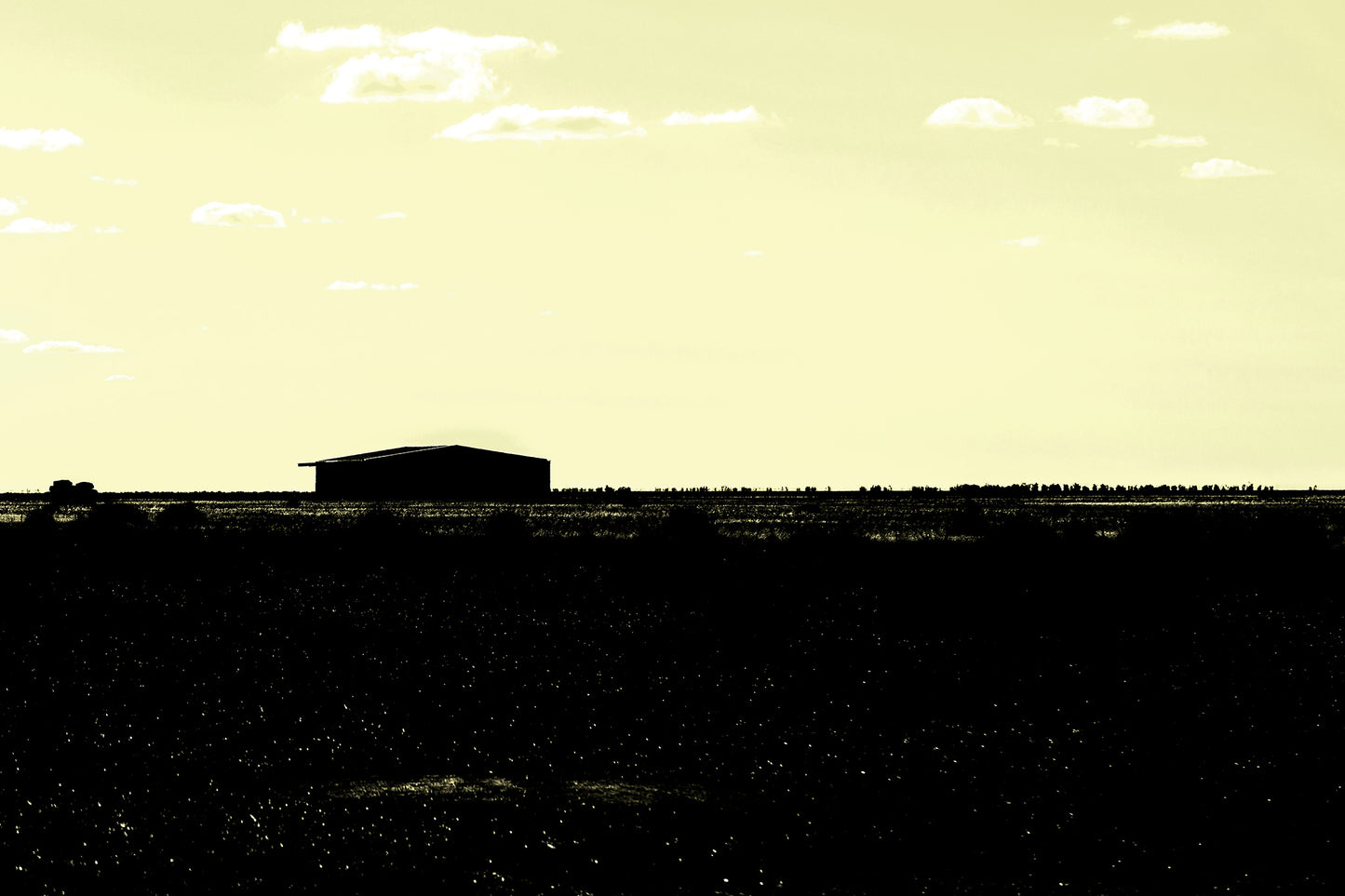 Vivid Country - Hay Plains Shed - 4945v17 - 90x60cm, a silhouetted shed on the vast Australian Hay Plains under a pale yellow sky, evoking stillness, space, and minimalist rural beauty.