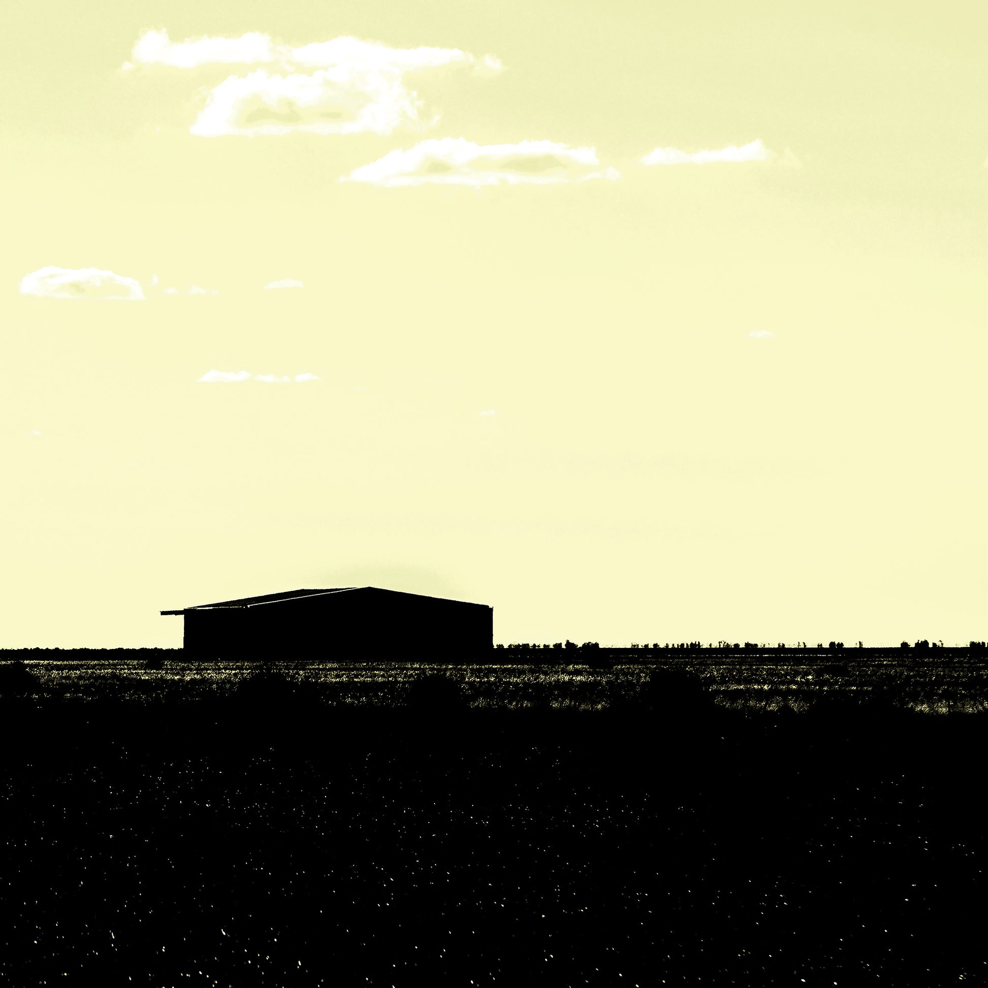 Vivid Country - Hay Plains Shed - 4945v17 - Close Detail View, a silhouetted shed on the vast Australian Hay Plains under a pale yellow sky, evoking stillness, space, and minimalist rural beauty.