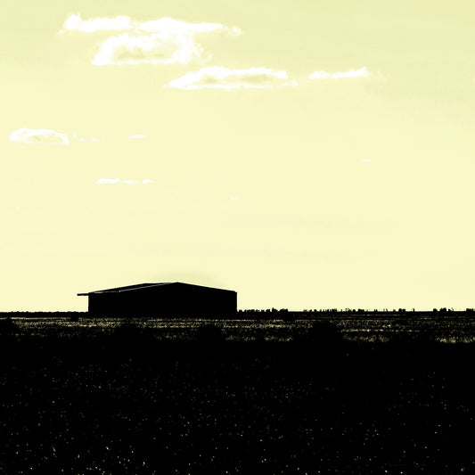 Vivid Country - Hay Plains Shed - 4945v17 - Close Detail View, a silhouetted shed on the vast Australian Hay Plains under a pale yellow sky, evoking stillness, space, and minimalist rural beauty.