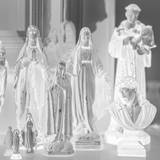 Monochrome Mix - Icons on the Mantel - 183072 - Close Detail View, A monochrome image of religious figurines grouped on a mantel, including various Madonnas, saints, and a bust of Christ, evoking a serene and personal shrine.