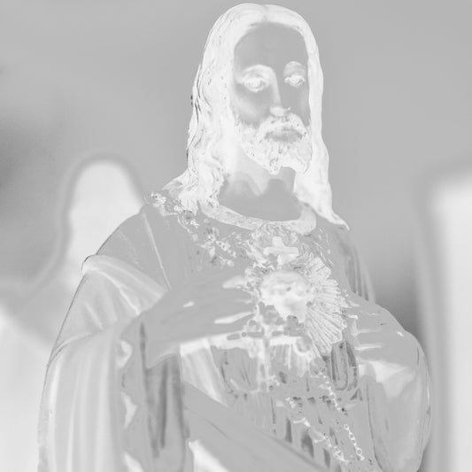 Monochrome Mix - Icons on the Mantel - 183081 - Close Detail View, Soft-focus black and white image of a Sacred Heart of Jesus statue, with subtle ethereal lighting evoking spiritual presence and quiet reverence.