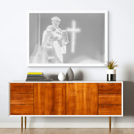 Monochrome Mix - Icons on the Mantel - 183102 - Room View, Black and white image of a Saint Anthony statue holding baby Jesus, with a glowing cross in the blurred background, evoking spiritual reflection and reverent stillness.