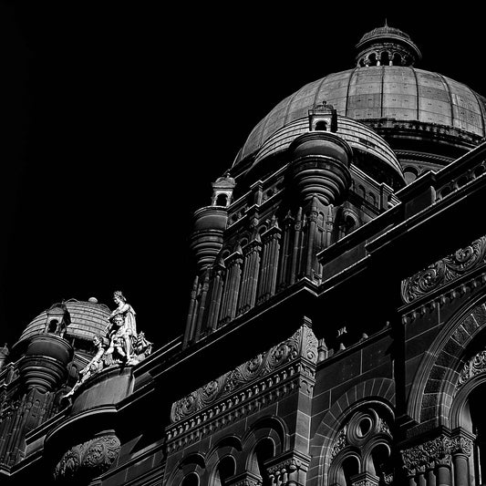 Monochrome Mix - Sydney - QVB - 231101v3 - Close Detail View, Black and white photograph of the Queen Victoria Building in Sydney, featuring ornate domes, detailed façade architecture, and classical sculpture against a dark sky.