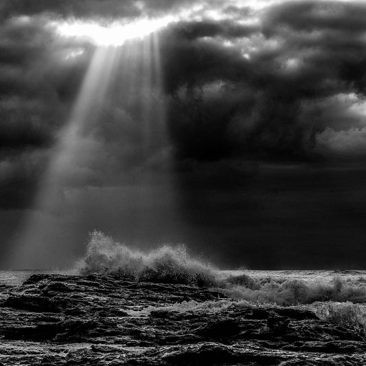 Monochrome Mix - Valla Beach - Cloud Burst - 171683 - Close Detail View, Black and white photograph of stormy ocean waves crashing on rocks beneath dramatic cloud cover, with beams of sunlight piercing through the clouds over Valla Beach.