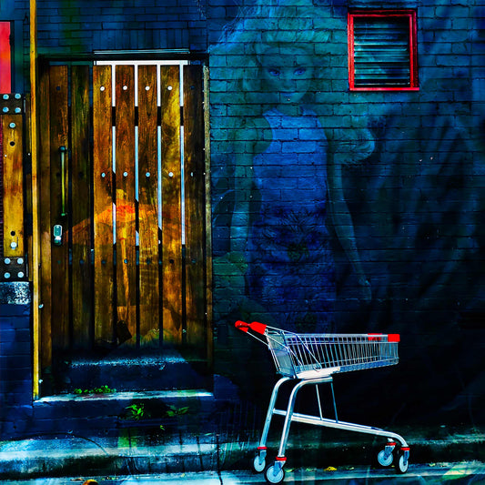 Trolley Dolly - Series No.2: 19E2255v12 - Close Detail View, a translucent doll like woman with blonde hair is layered against a dark blue brick wall. A red handled shopping trolley sits at the curb, and a wooden slatted door glows with hints of fruit and market textures. The scene symbolises homelessness, invisibility, and social neglect.