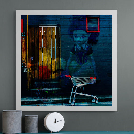 Trolley Dolly - Series No.3: 19E2255v2 - Room View, a fine art photograph featuring a stylised mural of a girl resembling Snow White painted on a dark brick wall next to a wooden door, with a red and silver shopping trolley in the foreground. The artwork contrasts innocence with urban decay.
