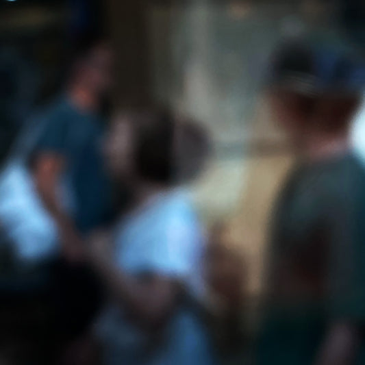 Urban Commute - Series No.1: 0959v1 - Close Detail View, a soft focus photograph of three indistinct commuters passing in golden light, with glowing bokeh orbs to the left. Evokes the quiet rhythm and abstraction of morning city life in motion. Photography by Raymond Mather. Limited edition fine art print.