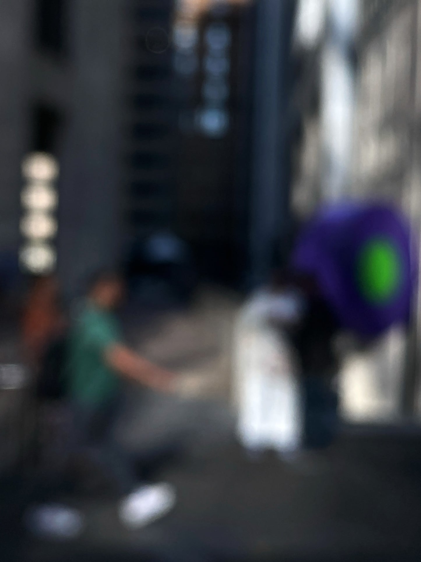 Urban Commute - Series No.1: 0960v1 - 67.5x90cm, a soft-focus image of a city commuter mid-stride beside a vivid purple umbrella, set between tall buildings in gentle light. An abstracted urban moment captured in motion. Limited edition fine art print by Raymond Mather.