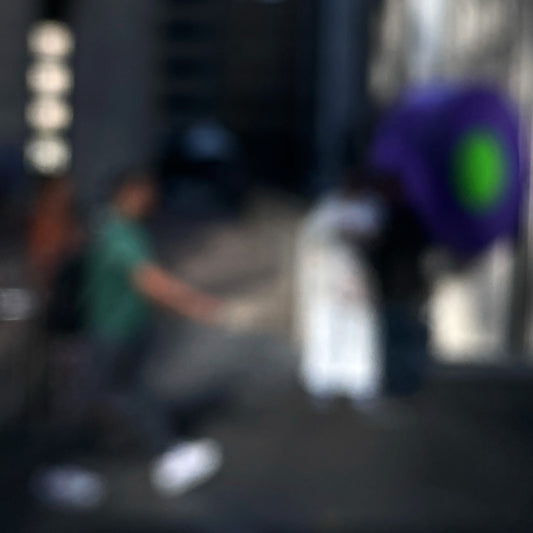 Urban Commute - Series No.1: 0960v1 - Close Detail View, a soft-focus image of a city commuter mid-stride beside a vivid purple umbrella, set between tall buildings in gentle light. An abstracted urban moment captured in motion. Limited edition fine art print by Raymond Mather.