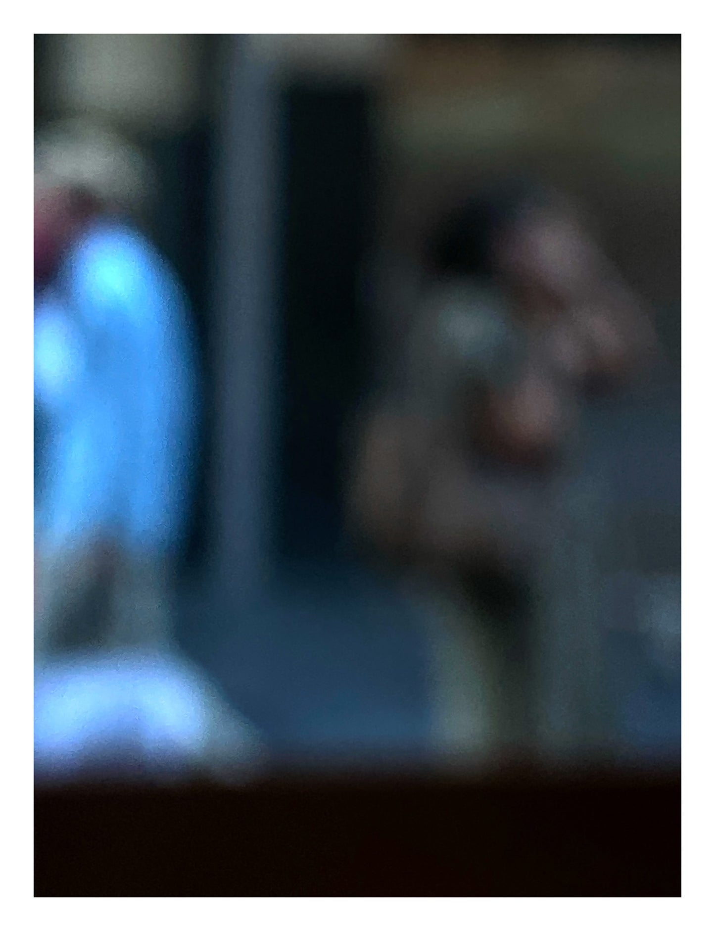 Urban Commute - Series No.1: 0978v1 - 81.5x104cm, a soft focus photograph of two city commuters: one in a blue shirt walking left, and another mid call, set against a shadowed urban backdrop. A contemplative image of separation and movement. Limited edition fine art print by Raymond Mather.