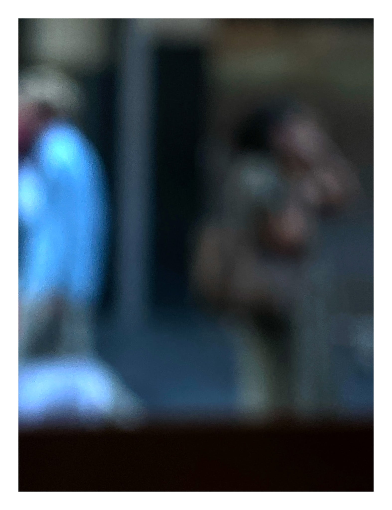 Urban Commute - Series No.1: 0978v1 - 81.5x104cm, a soft focus photograph of two city commuters: one in a blue shirt walking left, and another mid call, set against a shadowed urban backdrop. A contemplative image of separation and movement. Limited edition fine art print by Raymond Mather.