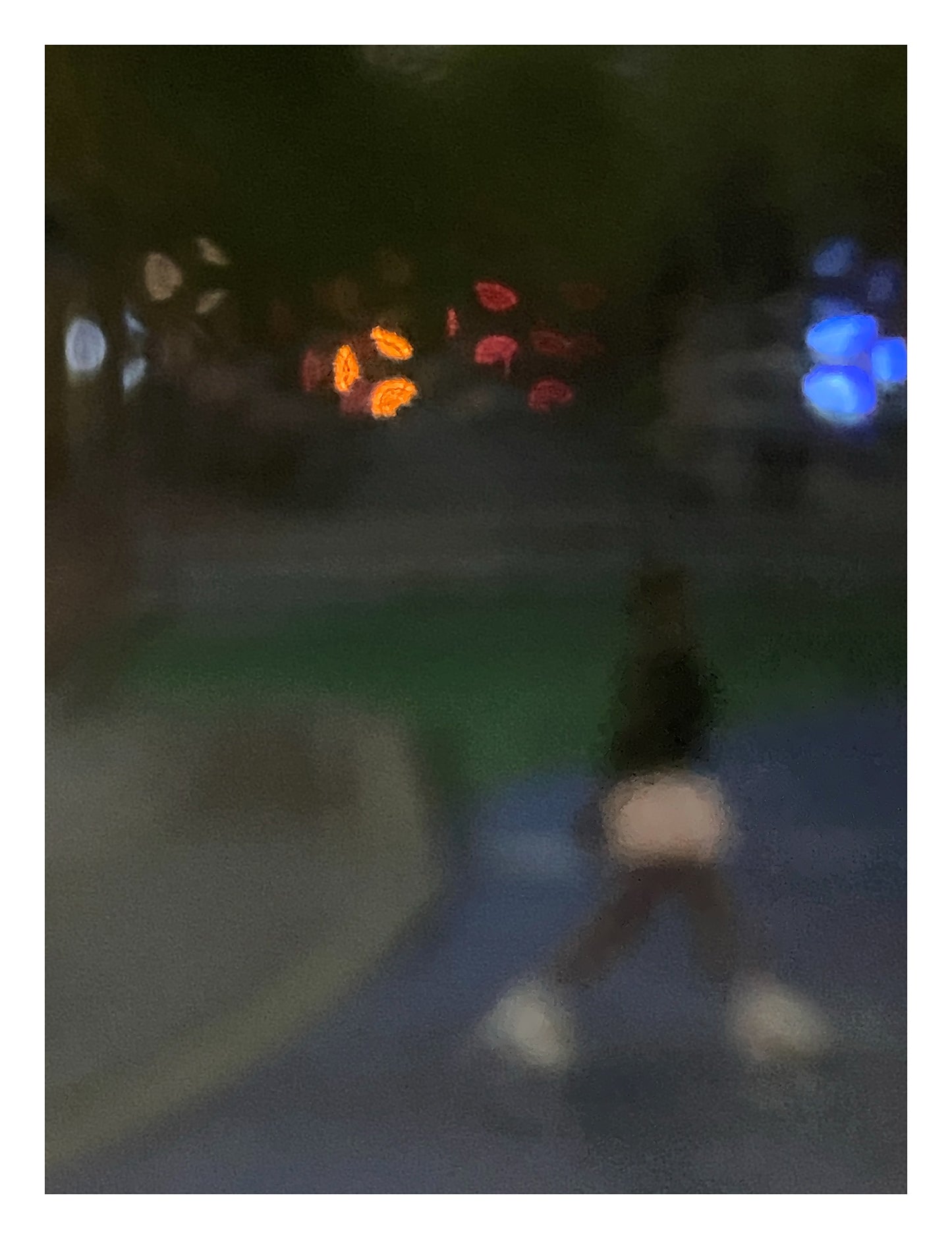 Urban Commute - Series No.1: 1206v1 - 81.5x104cm, a soft focus evening image of a single blurred commuter walking across a dim city path, with scattered lights in red, orange, and blue glowing in the distance. A moody, atmospheric urban scene in motion. Limited edition fine art print by Raymond Mather.