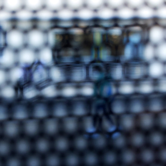 Urban Commute - Series No.2: 9150 - Close Detail View, fine art photograph by Raymond Mather showing a walking figure in blue, captured through a dense circular grid. A blurred train forms the backdrop, creating a quiet, geometric abstraction of city life in motion.