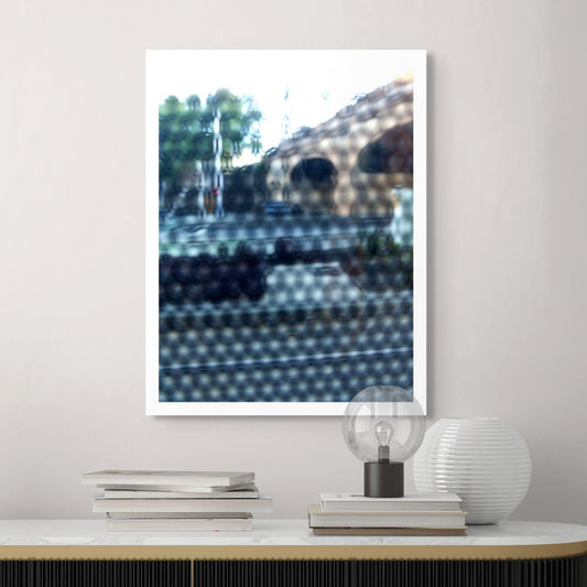 Urban Commute - Series No.2: 9164v1 - Room View, fine art photograph by Raymond Mather featuring a city street scene with a brick railway viaduct, trees, and soft reflections, viewed through a patterned surface. The image is blurred and dappled, evoking a quiet, abstracted sense of place and structure.