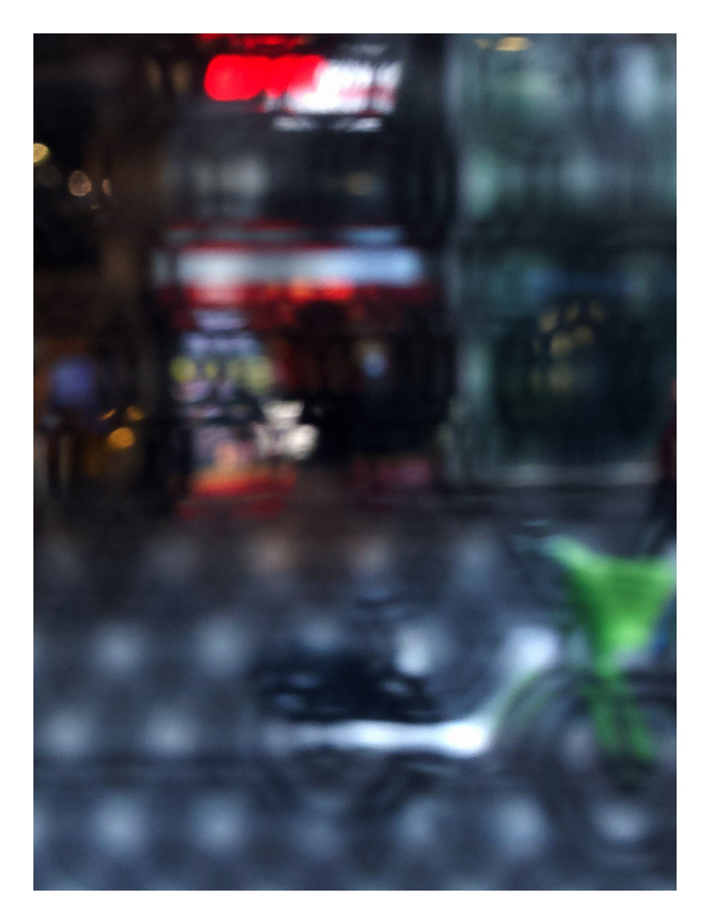 Urban Commute - Series No.2: 9206v1 - 81.5x104cm, fine art photograph by Raymond Mather featuring a blurred green bike in the foreground, with a red neon-lit storefront behind a softly distorted surface. A moody and abstract urban scene evoking energy and reflection.