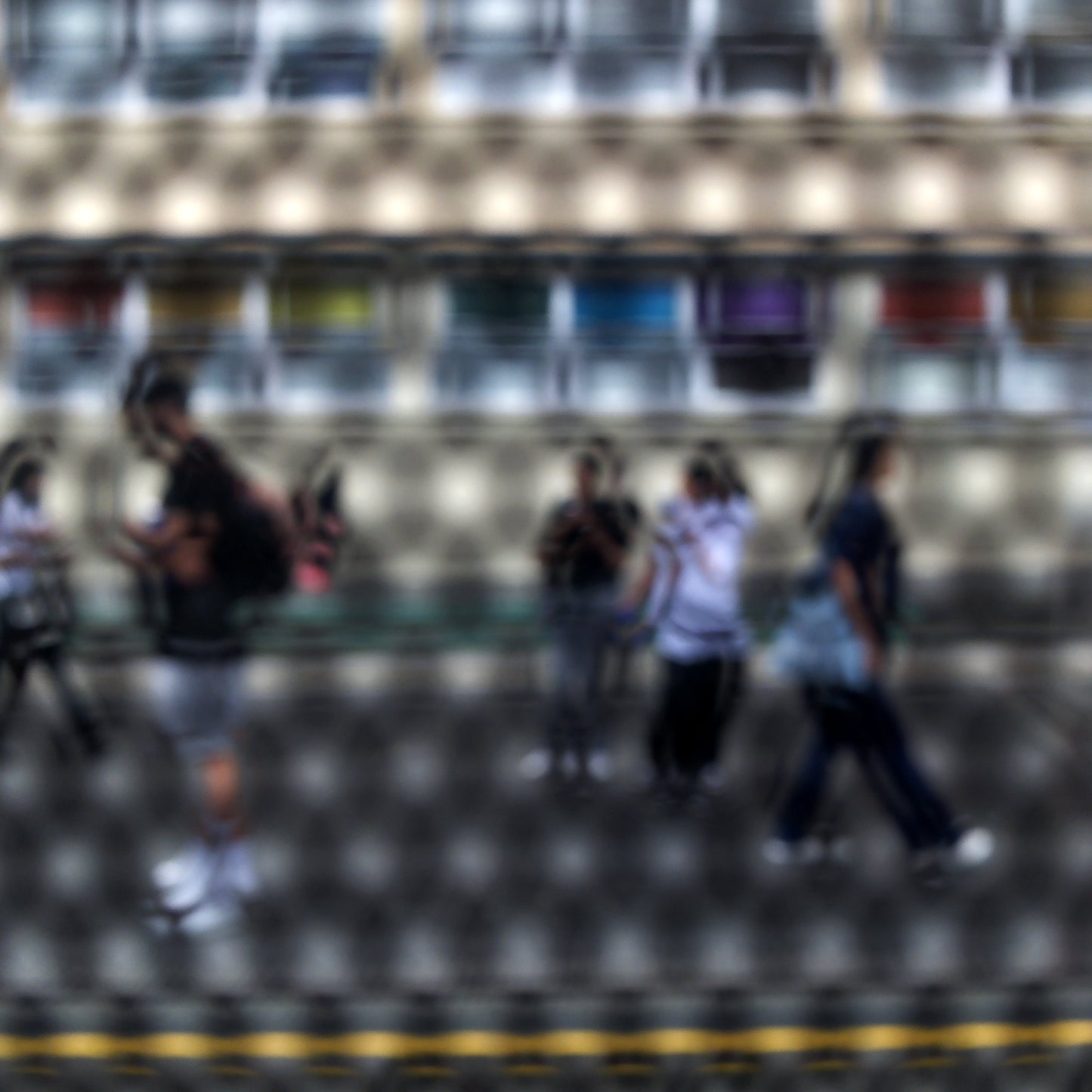 Urban Commute - Series No.2: 9558(1)v1 - Close Detail View, fine art photograph by Raymond Mather showing a group of pedestrians walking past a multicoloured glass façade, viewed through a circular screen. The image blurs motion, structure, and rhythm into a poetic urban abstraction.