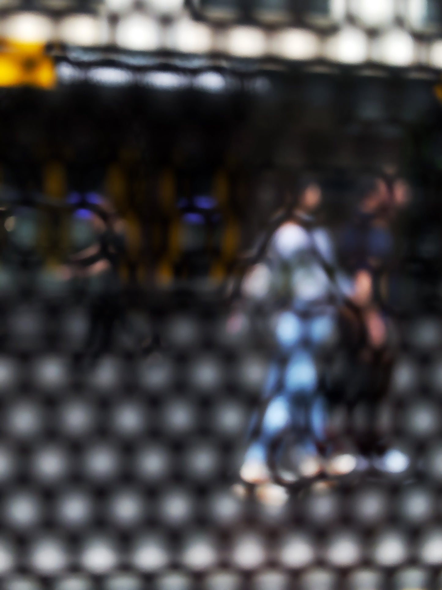 Urban Commute - Series No.2: 9611 - 67.5x90cm, abstract city street scene with two blurred figures walking side by side through a honeycomb patterned filter, with warm ambient light, soft shadows, and diffuse reflections suggesting early morning movement, limited edition fine art print by Raymond Mather, ART1.